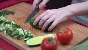 The chef cuts a cucumber on a bamboo Board, healthy eating, close up, time lapse video