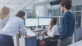 In the Bright Busy Office Diverse Group of Young Professionals have Team Building Meeting. Standing at the Desk, Discuss Problem Solutions, Planning and Strategizing, Use Digital Tablets and  Computer - Powered by Shutterstock - Get 15% off with code: PIKWIZARD15