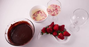 Speed up clip of Lady pouring melted chocolate into a glass with a mixture of condensed milk, cream, and strawberries to prepare a pave french dessert recipe 4K 30 fps