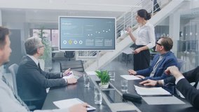 In the Corporate Meeting Room: Female Analyst Uses Digital Interactive Whiteboard for Presentation to a Board of Executives, Lawyers, Investors they Applaud. Screen Shows Company Growth Data - Powered by Shutterstock - Get 15% off with code: PIKWIZARD15