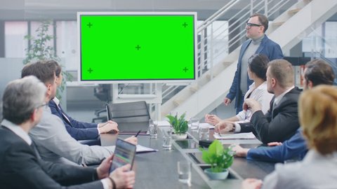 In the Corporate Meeting Room: Creative Director Uses Digital Chroma Key Interactive Whiteboard for Presentation to a Board of Executives, Lawyers, Investors. Green Mock-up Screen in Horizontal Mode
