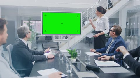 In the Corporate Meeting Room: Female Executive Uses Digital Chroma Key Interactive Whiteboard for Presentation to a Board of Directors, Lawyers, Investors they Applaud. Green Mock-up Screen