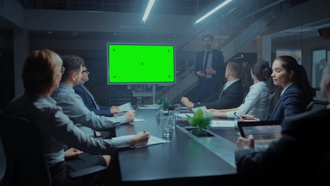 Late at Night In the Corporate Meeting Room: Director Talks and Uses Digital Chroma Key Interactive Whiteboard for Presentation to Executives, Investors. Green Mock-up Screen in Horizontal Mode