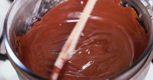 Slow motion Closeup clip of melting dark, milk, and black chocolate in double boiler water bath bain-marie 