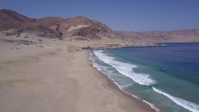 Cifuncho beach aerial footage at Atacama Desert the sunset ray lights illuminate this amazing and idyllic beach in the middle of the desert, an arid awe landscape crashed by Pacific Ocean waters