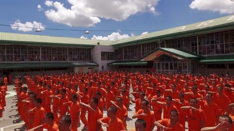 CEBU PROVINCIAL DETENTION AND REHABILITATION CENTER, CEBU, PHILIPPINES - March 2016. Cebu's dancing inmates surrounded by tourists. Choreographic practices show for tourists - aerial 4K view.