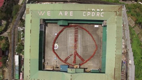 CEBU PROVINCIAL DETENTION AND REHABILITATION CENTER, CEBU, PHILIPPINES - March 2016. Choreographed exercise routines of the inmates. Aerial 4K view of the prisoners forming a sign within prison yard.