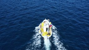 Aerial drone video of beautiful traditional fishing boat cruising near picturesque village of Parga with deep blue sea, Ionian, Greece