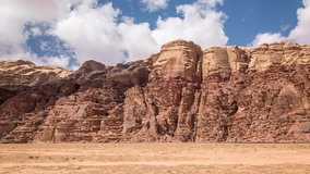 Wadi Rum desert in Jordan, Middle East. White clouds move fast over the red rocks. Time lapse video