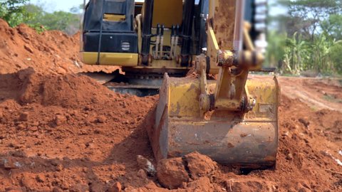 Video shot of Construction Excavator Scooping and Dumping on Dirt Pile