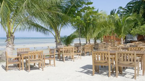 Table and chairs at restaurant at tropical beach
