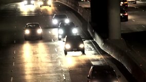 This telephoto time lapse video shows busy freeway traffic at night.