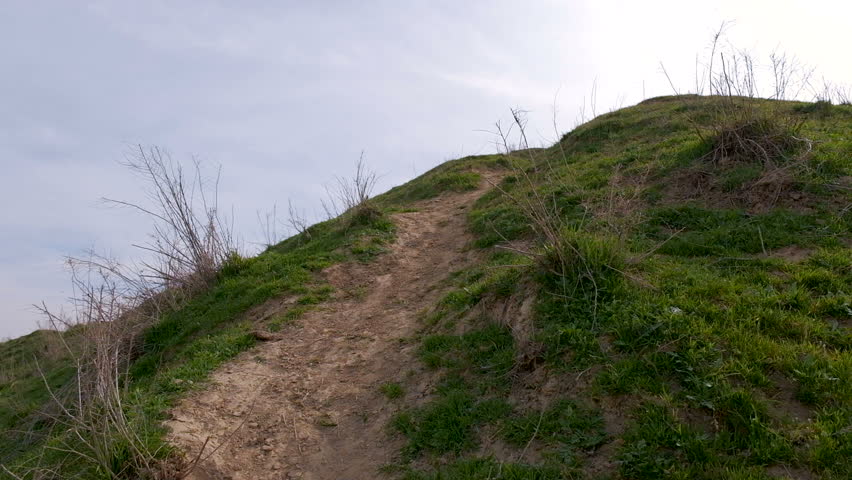 Climbing up the green hill in cloudy weather