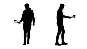 Two silhouettes shooting themselves while walking using steadicam and smartphone.