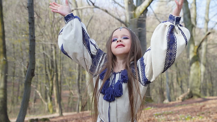 Cute little girl spinning around in the Park around the trees