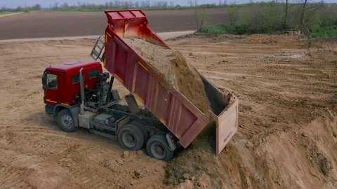 Dump Truck Unloads Sand in Construction. Aerial view