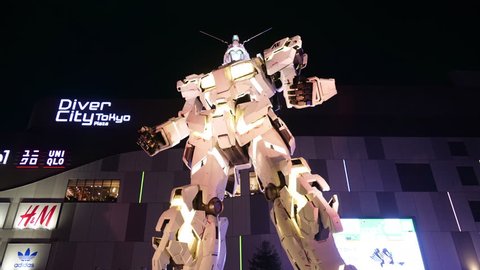 TOKYO, JAPAN - 2018 circa: A life-sized RX-0 Unicorn Gundam statue on display outside DiverCity Tokyo Plaza in Odaiba. 4K night hyper lapse