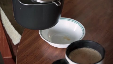 pouring indian tea in bowl and coffee mug