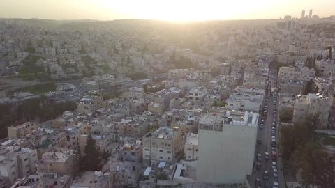Aerial drone clip of beautiful early morning at Amman Jordan with the sun just risen over the city skyline giving a peaceful atmosphere with traffic increasing