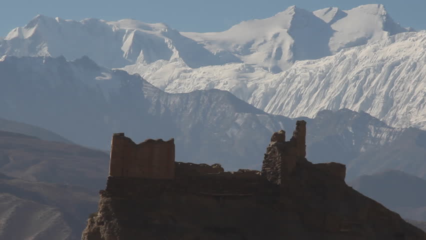 View of damaged top of building with breathtaking snow capped mountains in the background in Nepal