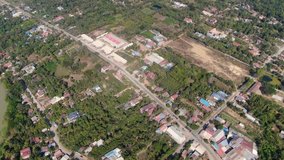 Aerial clip of outlying areas along Sangkae River in Battambang Cambodia during a summer day
