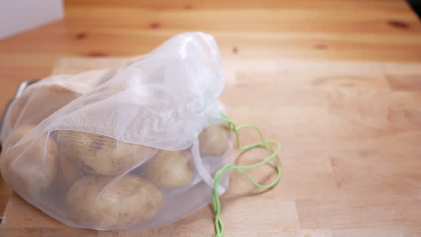 zero waste lifestyle concept. Pull off potatoes of reusable bag, up view. Healthy Organic Food
