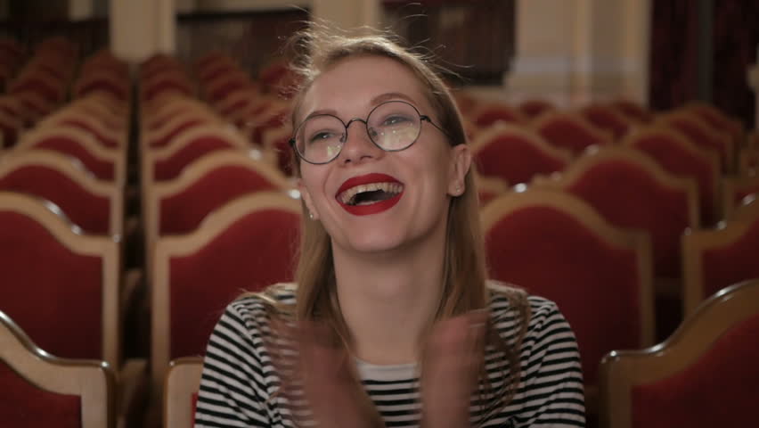 Portrait of woman sitting in empty auditorium in theatre