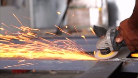 Worker cutting metal with grinder. Sparks while grinding iron HD video.