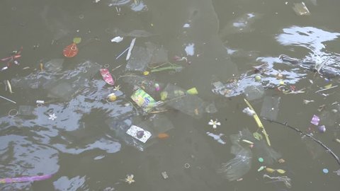 Many plastic garbage floating in a river. Filmed on April, 17 2018 at Chao Phraya River of Bangkok, Thailand