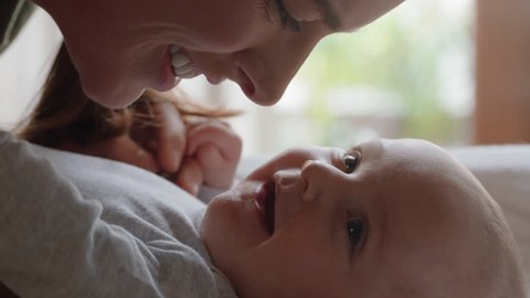 close up mother kissing happy baby laughing enjoying loving mom nurturing toddler at home