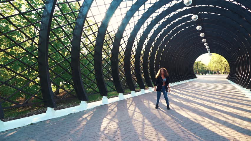 Girl dancing on a sunny day in the park.
