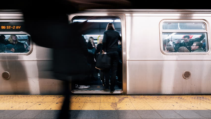 New York City, United States - Apr 4, 2019: Time-lapse of people waiting and boarding trains at subway station platform in New York city, USA. American city life, or public transportation concept