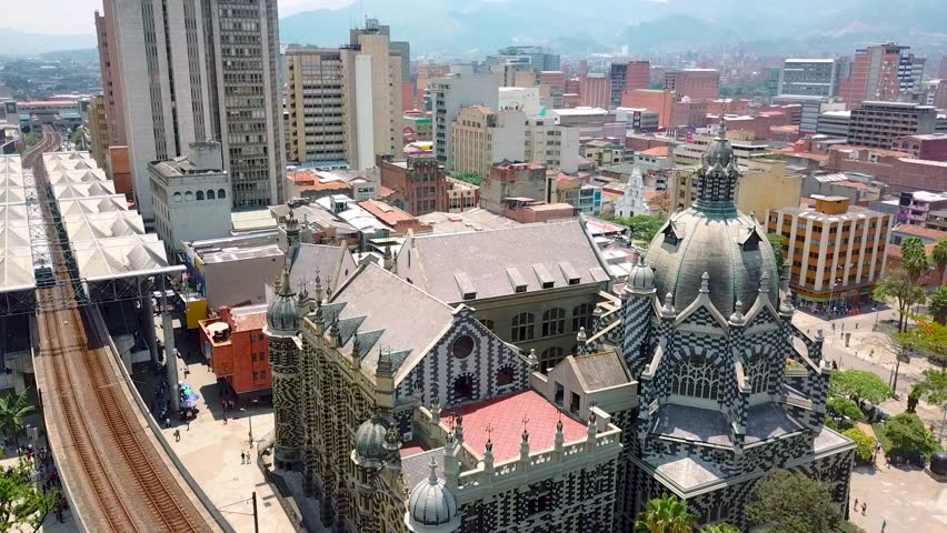 Beautiful aerial shot of metro train passing Botero square while entering station in sunny day