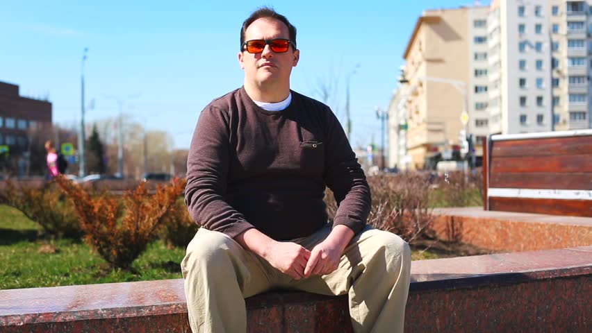 Transfer bribes in the street. A man gives money in an envelope to another man while sitting on the bench in the park
