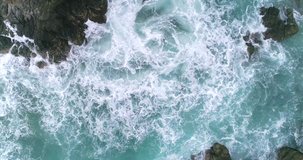 Aerial cenital shot of waves passing throw the cave of a rock formation Zipolite, Oaxaca
