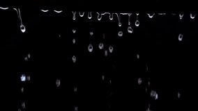 Dripping water (rain) on black background, Slow motion (120 FPS).
