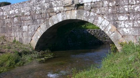 A Roman bridge with a river.