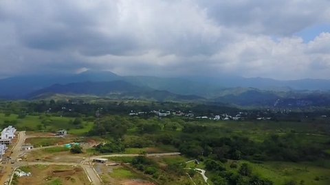 AERIAL: extremely slow progress towards the mountains in the horizon in Cali, Colombia on an overcast day.