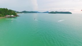 Aerial View of People are playing jet ski in the sea. Amazing video. The color of the water is green turquoise. An adventure day. 