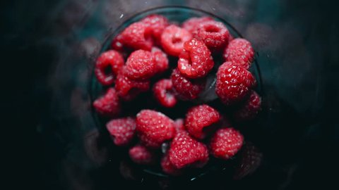 A pile of fresh raspberry berries quickly freeze in a glass. Healthy food. 4K timelapse