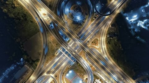 Hyperlapse timelapse of night city traffic on 4-way stop street intersection circle roundabout in bangkok at night, thailand. 4K UHD horizontal aerial view.
