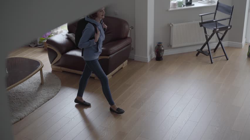 Slim woman walk inside beautiful house with comfortable backpack at the back and blond beautiful woman meet her with big smile and fix bag at back. Top view