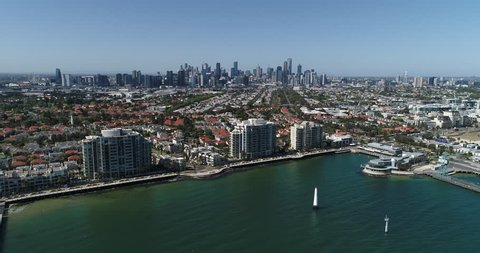 Aerial shot of melbourne skyline, Australia, with hi-rise port melbourne buildings, and beach in foreground on blue sky day, drone.