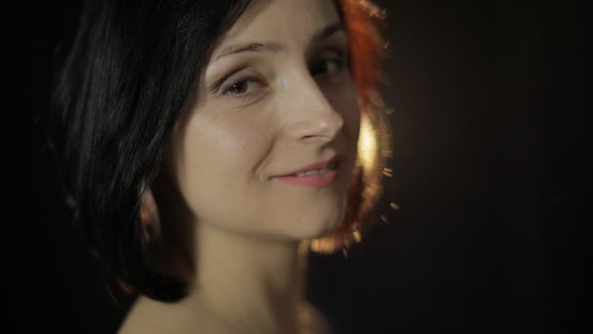 Beautiful, young woman smoking hookah. Attractive girl smoking flavored tobacco. Blow out smoke close-up on black background. Slow motion