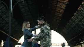 Happy Caucasian soldier throws his backpack to embrace his beloved girlfriend, wife, sister on a railway station. Army soldier returning home to the embrace of his wife. True love, happy reunion - Powered by Shutterstock - Get 15% off with code: PIKWIZARD15