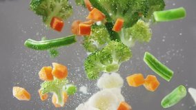Fresh vegetables falling under water on white background in slow motion. Salad, healthy food, delicious. Diet, vegetarian lifestyle, eco products, organic. Vitamins. Close up view - Powered by Shutterstock - Get 15% off with code: PIKWIZARD15