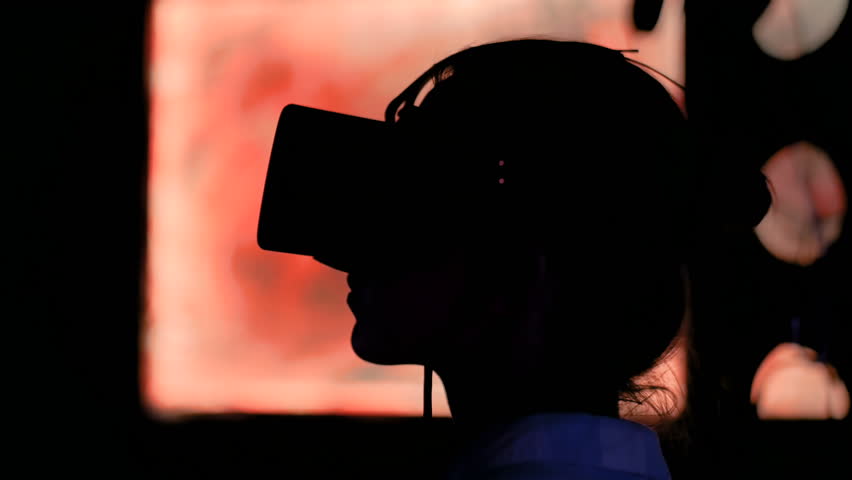 Woman using virtual reality headset and looking around at interactive technology exhibition. VR, augmented reality, digital art, futuristic, interactive, immersive and entertainment concept | Shutterstock HD Video #1028830373