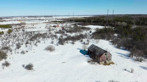 Rusty old barn in winter forest by drone.