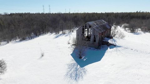 Abandoned red barn in Canadian forest.