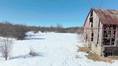 Side view of abandoned old red Canadian barn by drone.